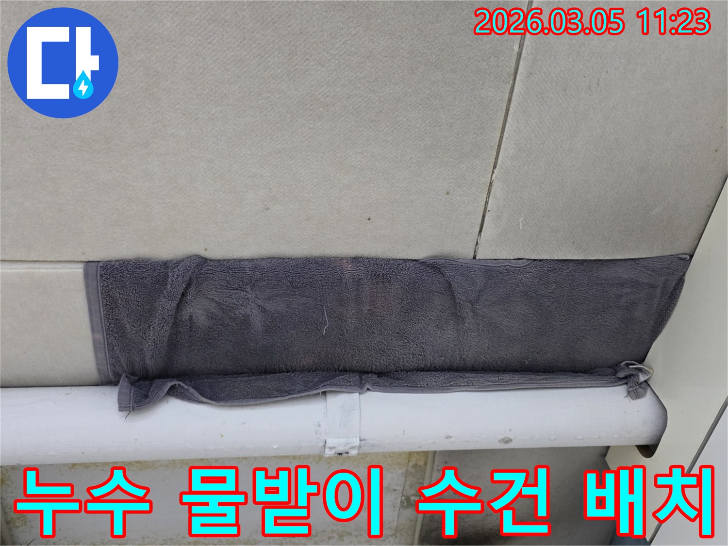 누수 지점에서 물이 떨어지는 것을-수건으로 받아내고 있는 상황-고객님의 빠른 대처가 돋보입니다