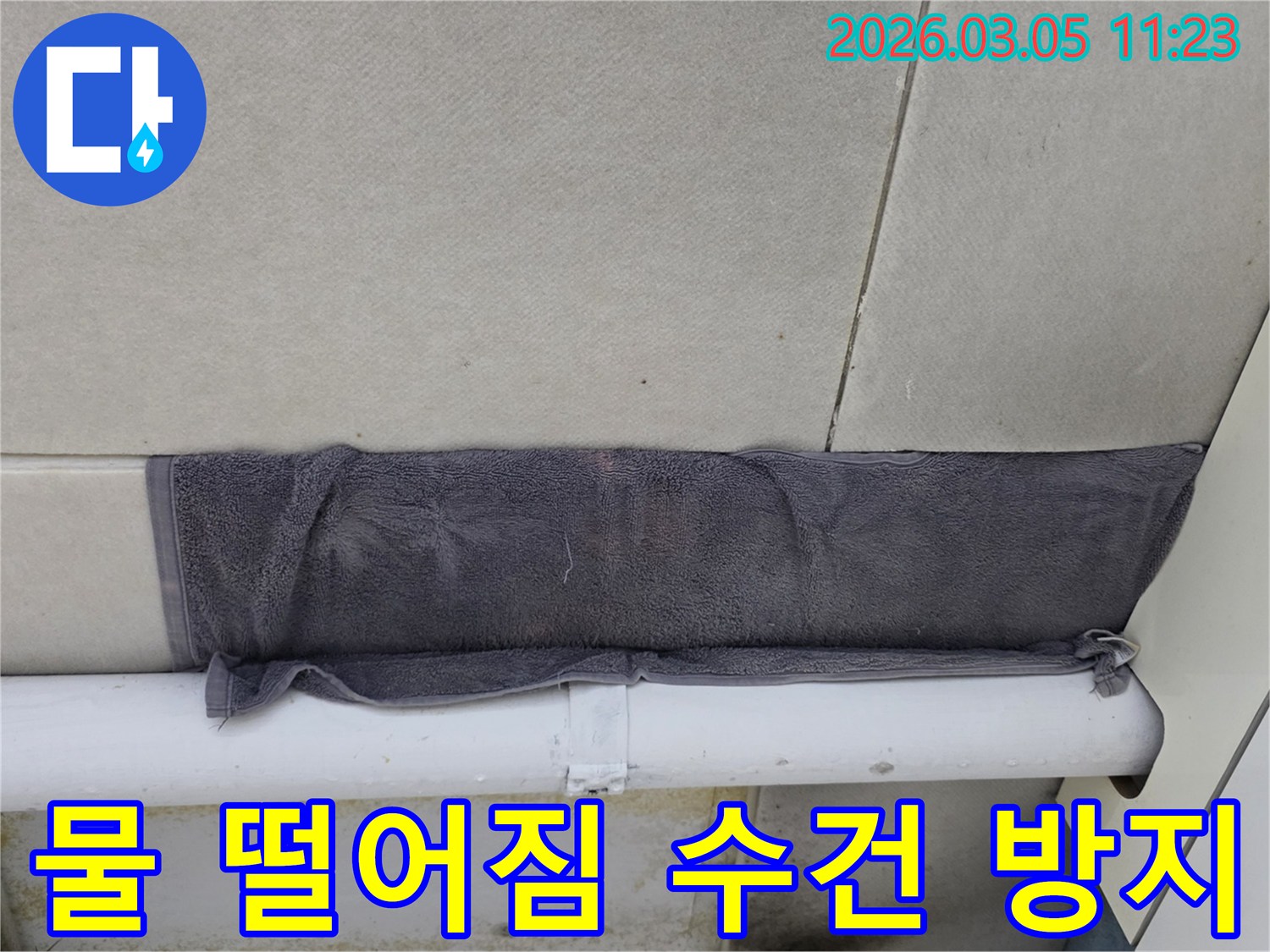 천장 타일 사이로 새는 물을-수건으로 임시적으로 막아둔 모습-누수 발생 시 초기 대응의 중요성