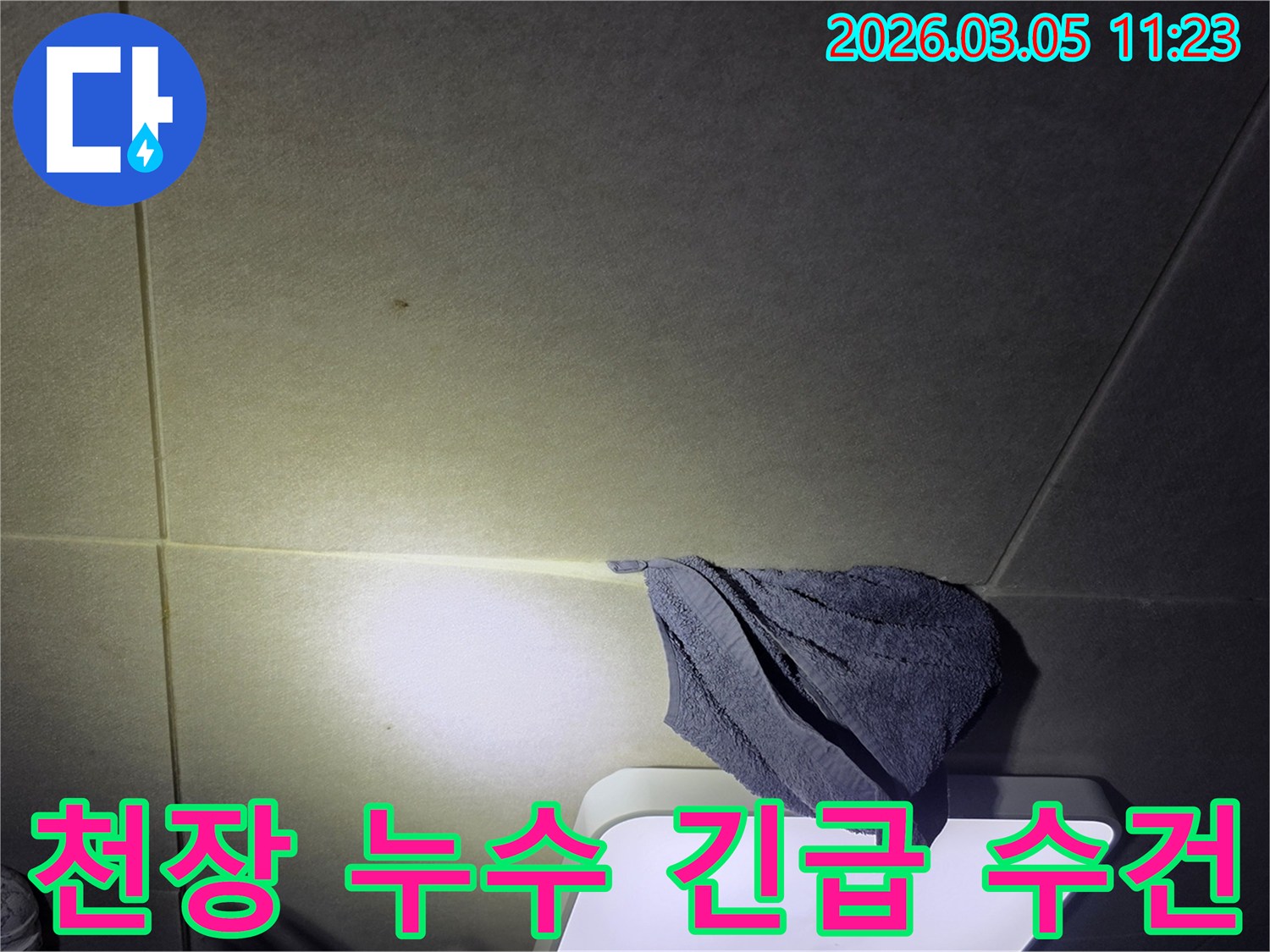 천장에서-물이-새어-나와-수건으로-긴급하게-받치고-있는-누수-피해-상황