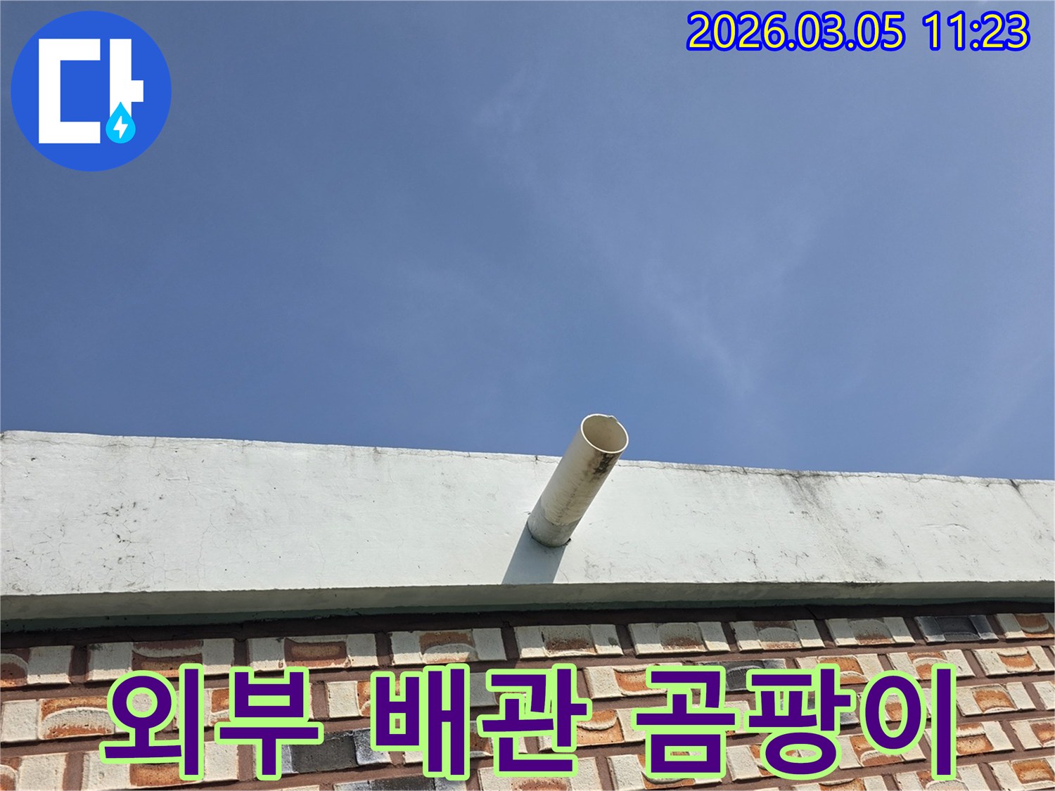 푸른-하늘을-배경으로-옥상-난간에서-돌출된-배수관-주변에-곰팡이-여부를-확인하는-사진입니다.