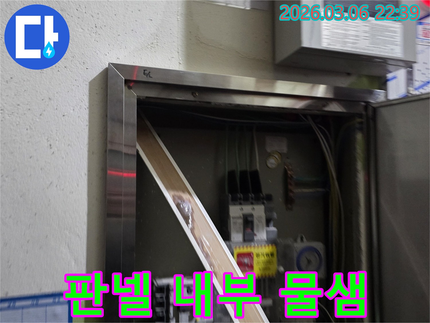 누수로 인해 전기 패널의 일부가-젖어있는 상태를-명확하게 보여주며-즉각적인 조치의 필요성을-알려줍니다.