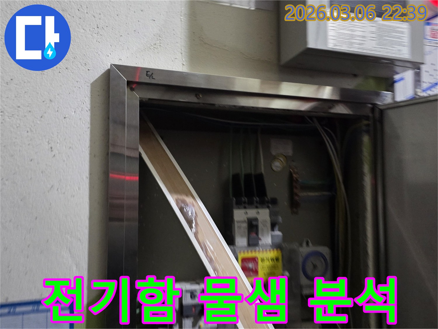 누수로 인해 전기 패널의 일부가-젖어있는 상태를-명확하게 보여주며-즉각적인 조치의 필요성을-알려줍니다.