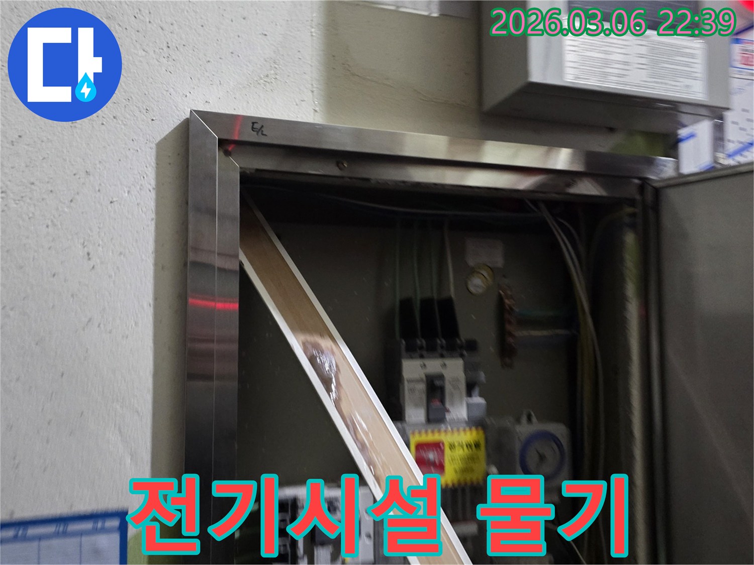전기함 안으로 스며든 물로 인해-전기 부품들이 손상될 위험이 있는-긴급한 누수 상황을-보여주는 이미지입니다.