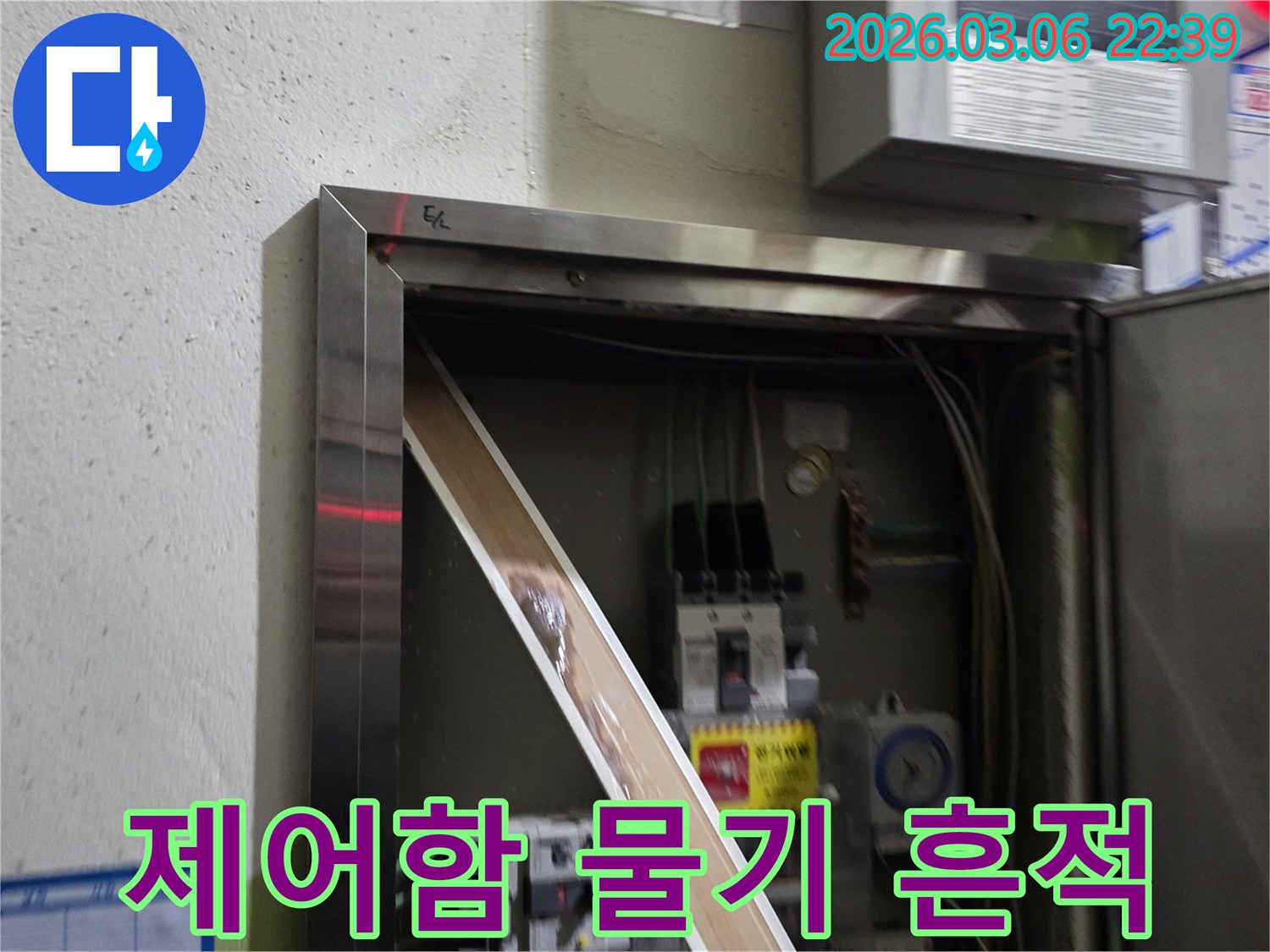 전기함 안으로 스며든 물로 인해-전기 부품들이 손상될 위험이 있는-긴급한 누수 상황을-보여주는 이미지입니다.