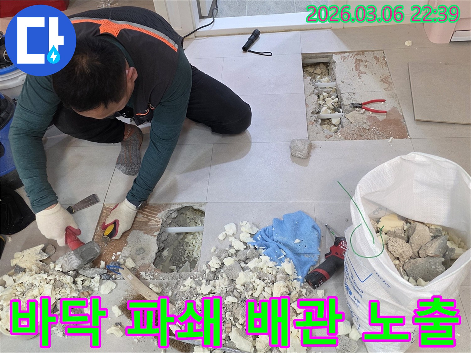 전문 엔지니어가 주택 누수 지점을-정확히 찾아내기 위해 바닥을 파쇄하고-배관을 노출시켜 점검하는 모습입니다