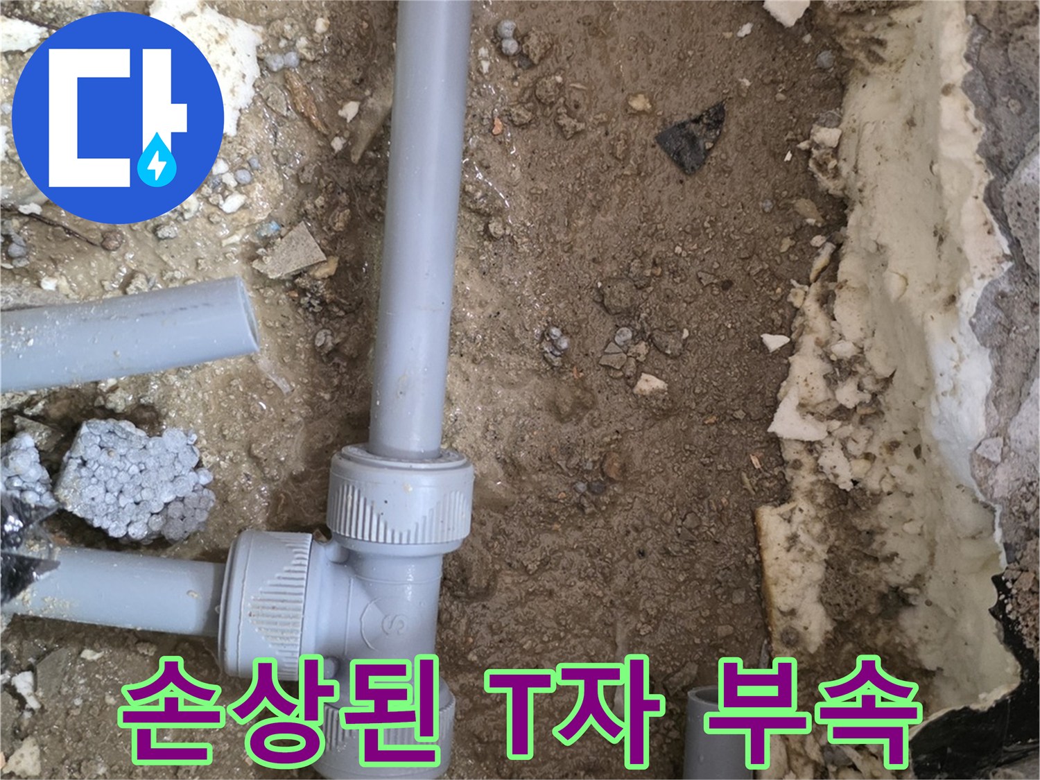 파손되어 물이 새고 있는 회색 배관의 T자 연결 부위