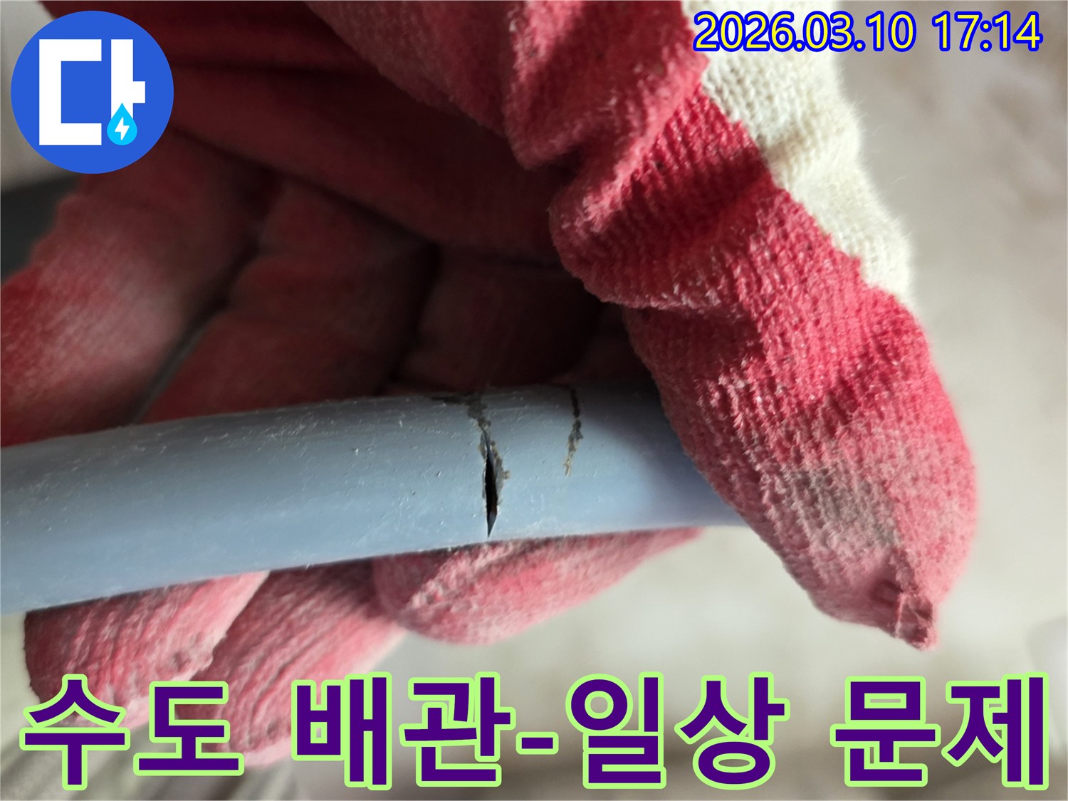 작업용 장갑을 낀 손이-일상에서 흔히 발생하는 수도 배관의 파열을 잡고-전문가의 해결을 기다립니다