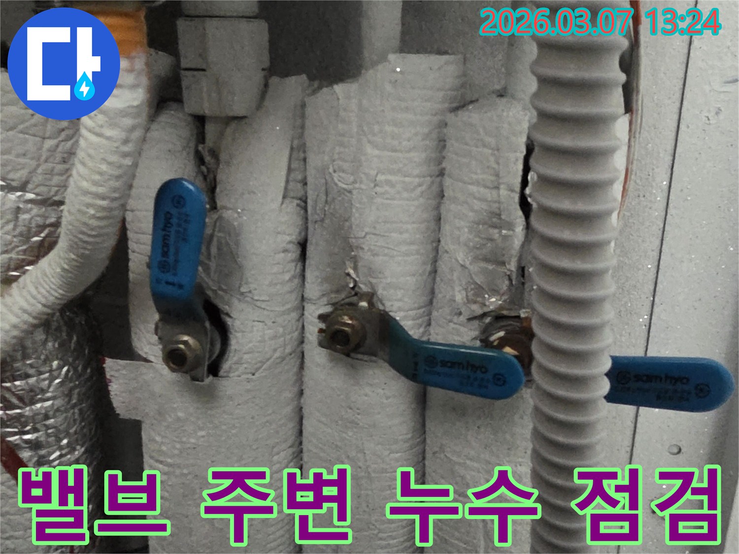 배관에 설치된 밸브 주변의 단열재가 손상된 곳을 중심으로 누수 여부를 확인하는 장면입니다.