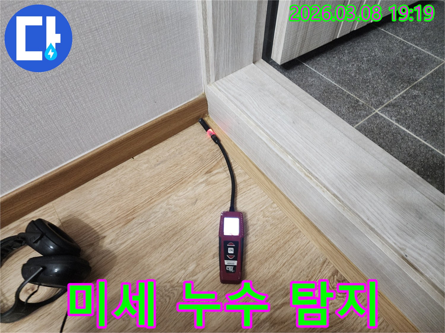 나무-마루와-벽면-사이의-틈새에서-누수탐지기가-작동하여-습기-반응을-보이는-사진