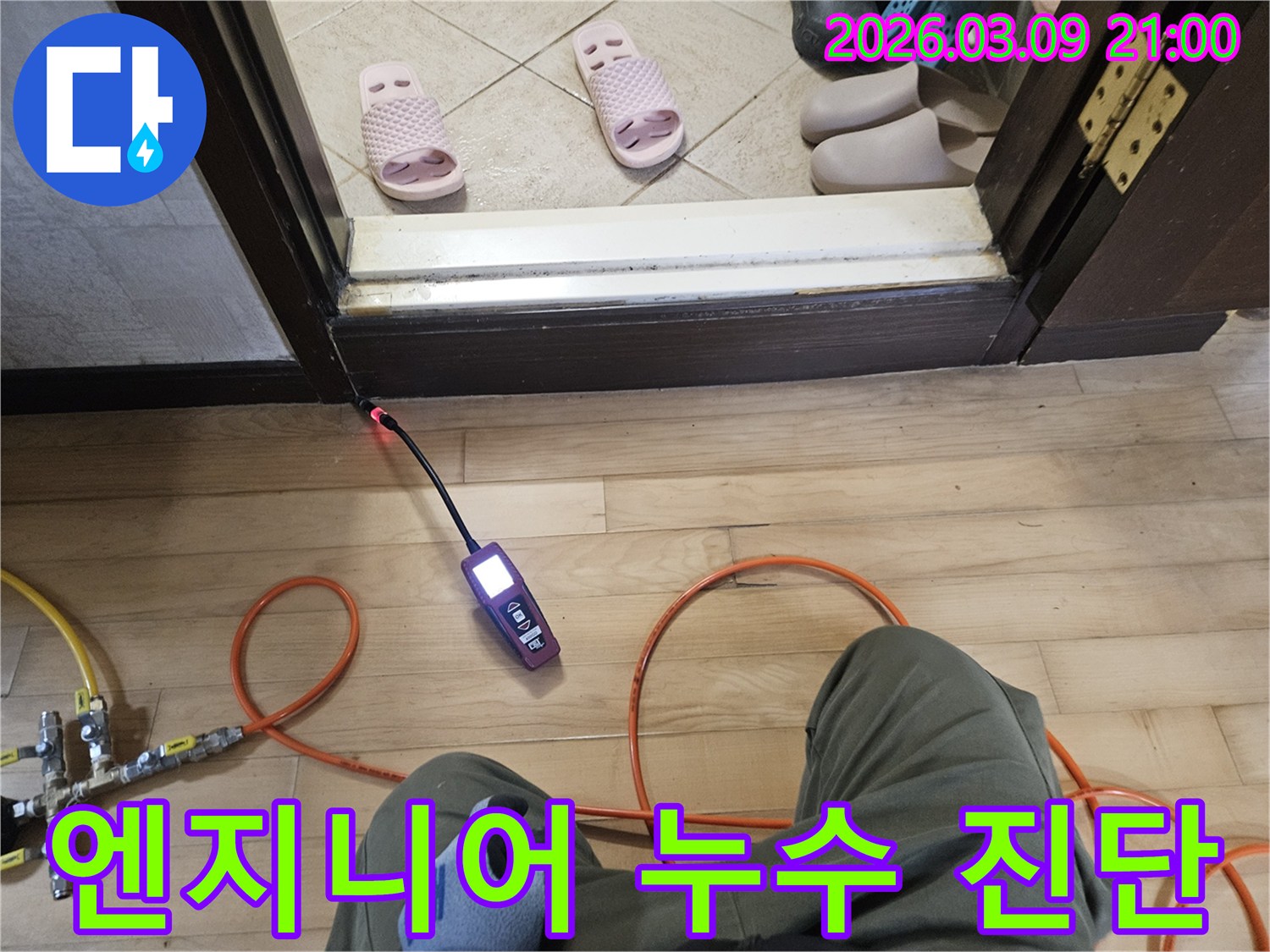 누수 전문 엔지니어가-탐지 장비를 들고-문턱 누수 지점을-세심하게 진단하는 모습