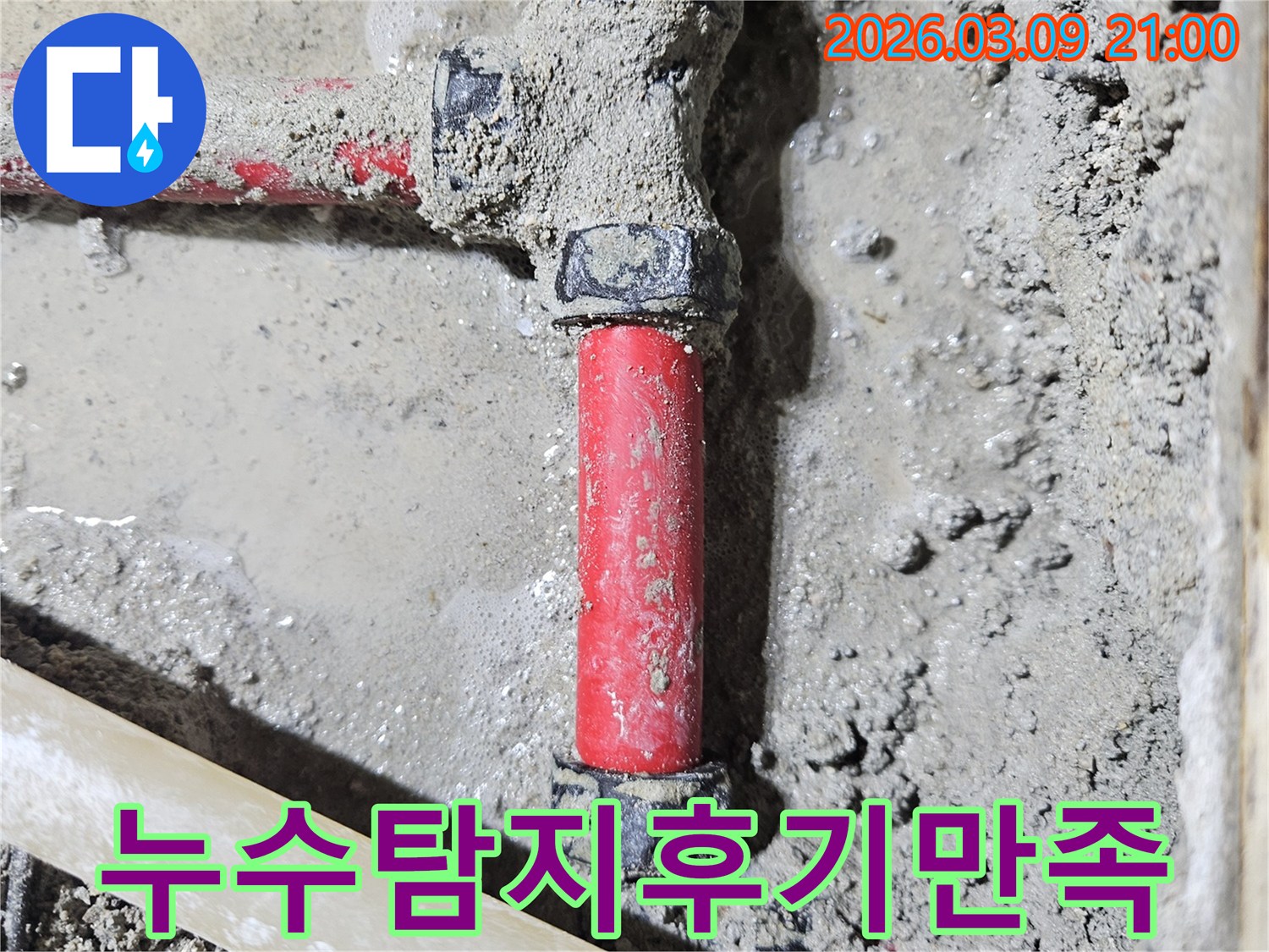 젖은 시멘트 바닥에-매립된 빨간색 배관의-누수 지점을-정확히 찾아내어-고객 만족을 이끌어낸-보수 현장입니다
