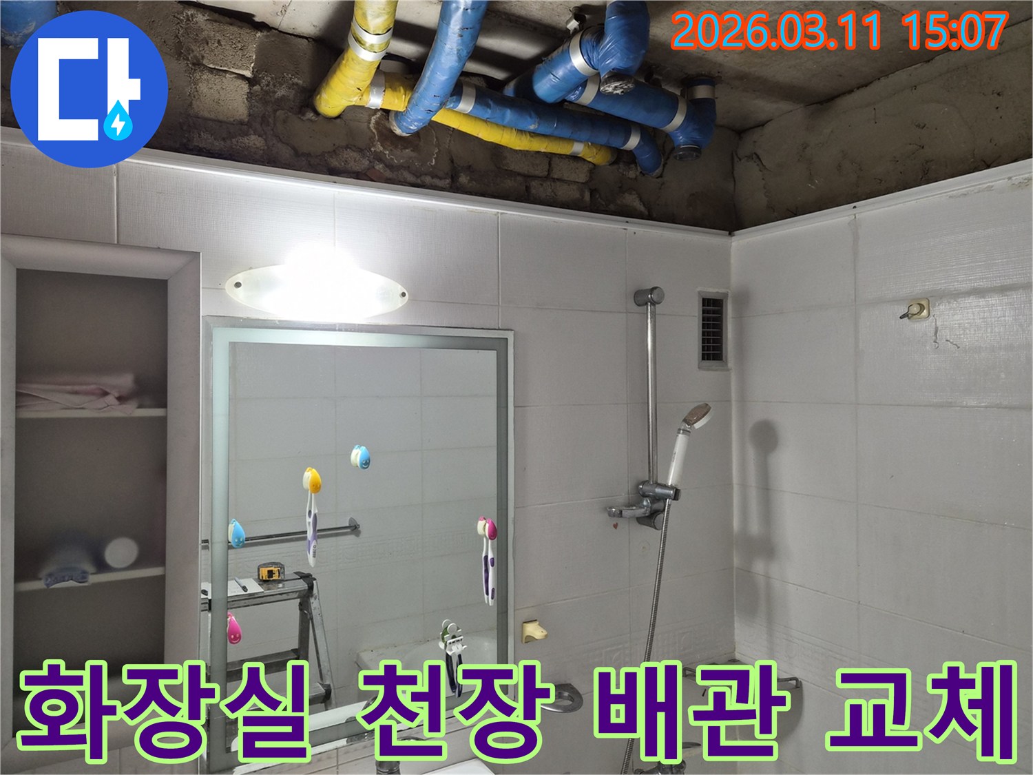 화장실 천장 내부의-오래된 파란색과 노란색 배관들이-새로운 배관으로-교체하기 위해-노출된 현장