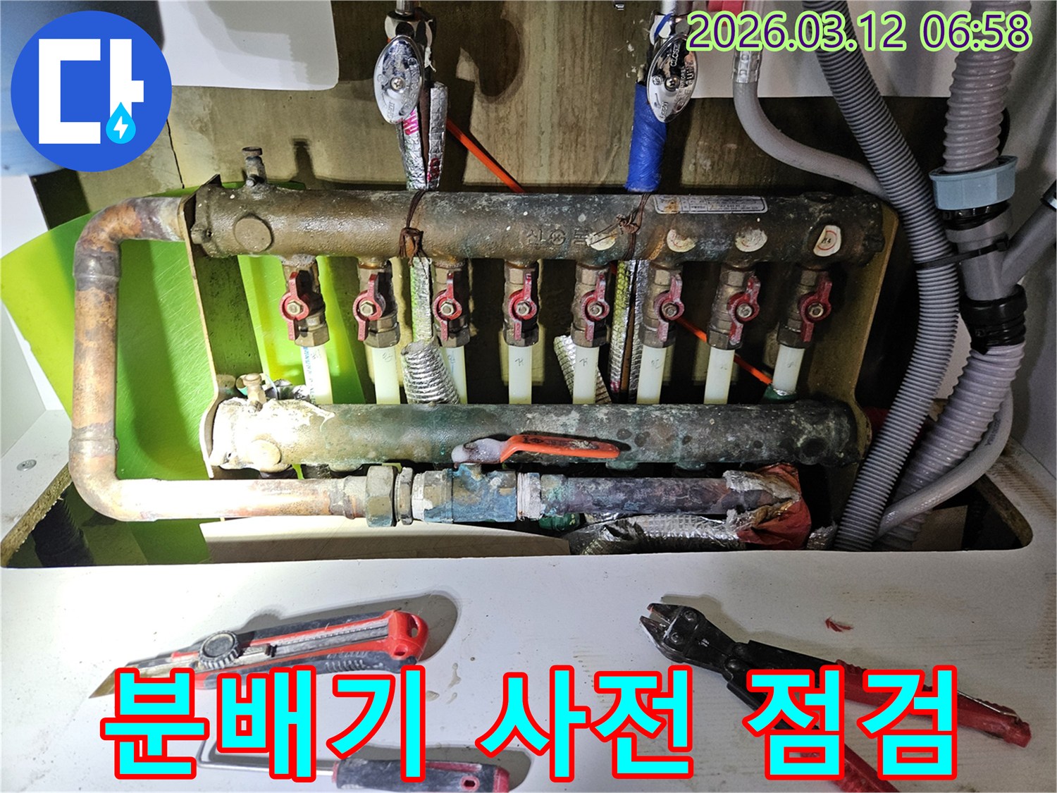 겨울철 동파 및 누수 예방을 위해-주택 난방 분배기를-전문가가 꼼꼼하게 사전 점검하는-과정을 담은 사진입니다