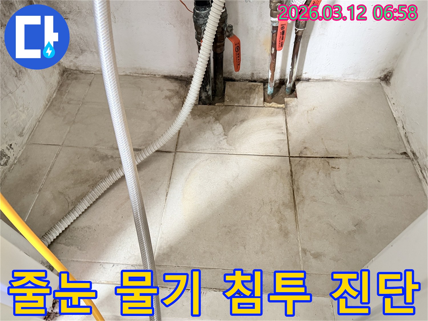 바닥-타일-줄눈에-고인-물기와-배관-주변의-습한-환경을-보여주는-누수-현장-사진