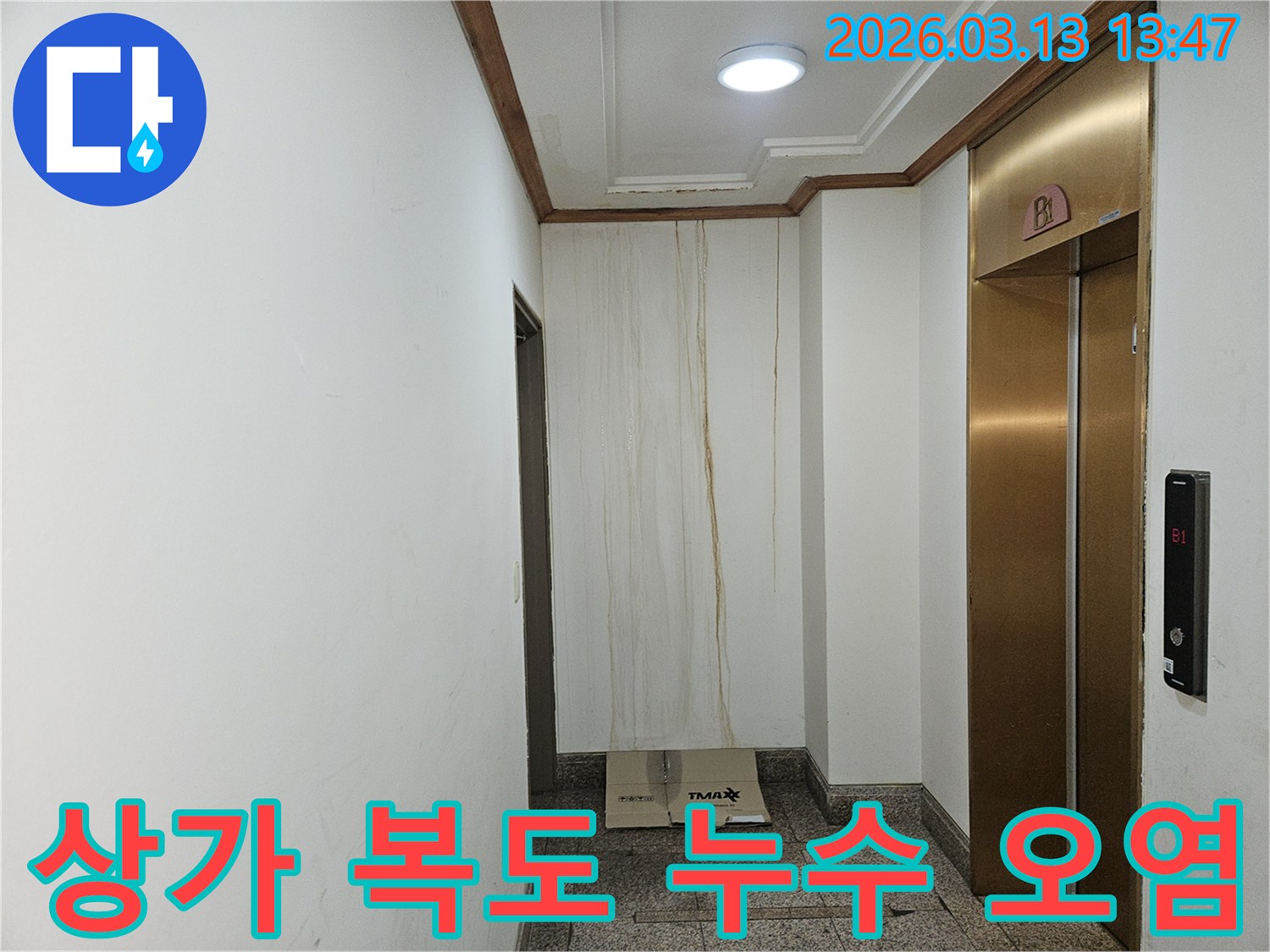 이 사진은 상가 복도 벽면에 발생한 누수로 인해-물이 흘러내려 심하게 오염된 모습을 보여줍니다-천장과 벽의 경계에서 누수가 시작된 것으로 보입니다