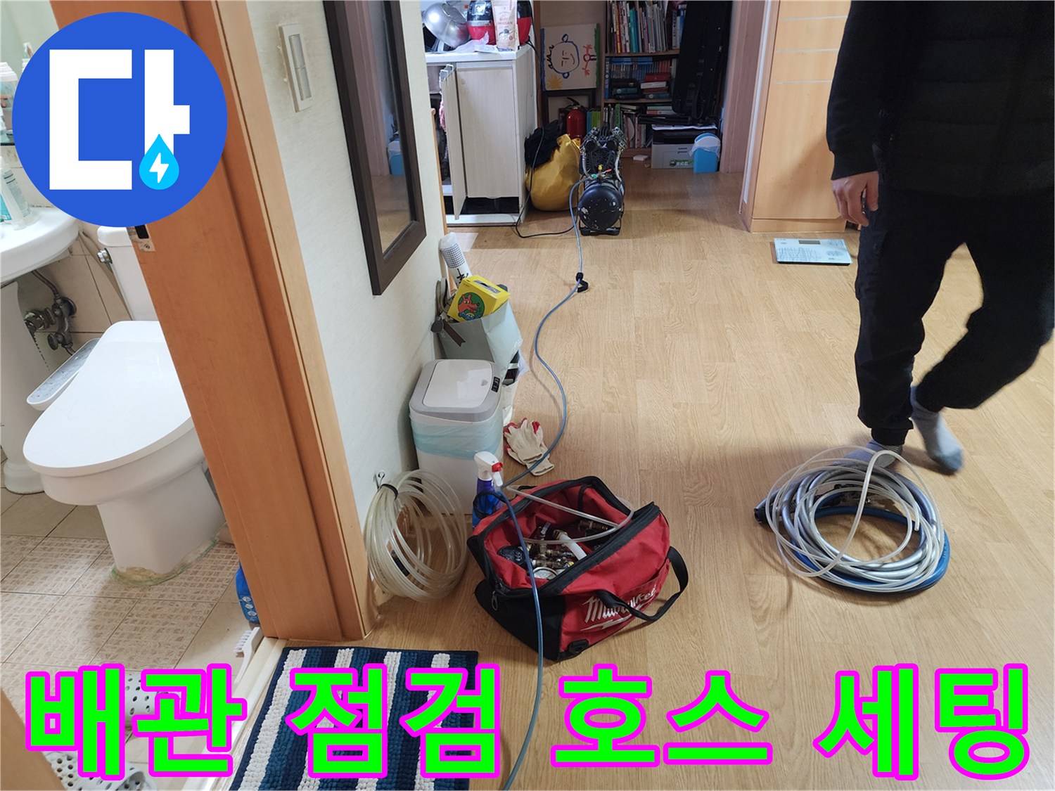 바닥에 펼쳐진 파란색과 흰색의 배관 압력 테스트용 호스