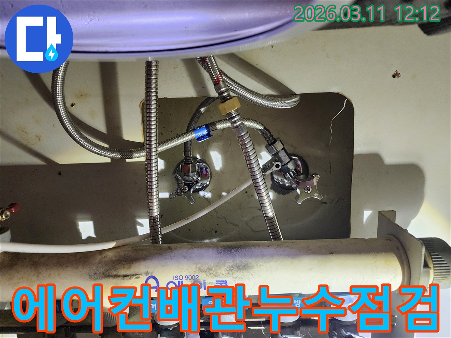 숙련된-엔지니어가-복잡한-수도-배관-연결부위의-누수-여부를-확인하는-장면