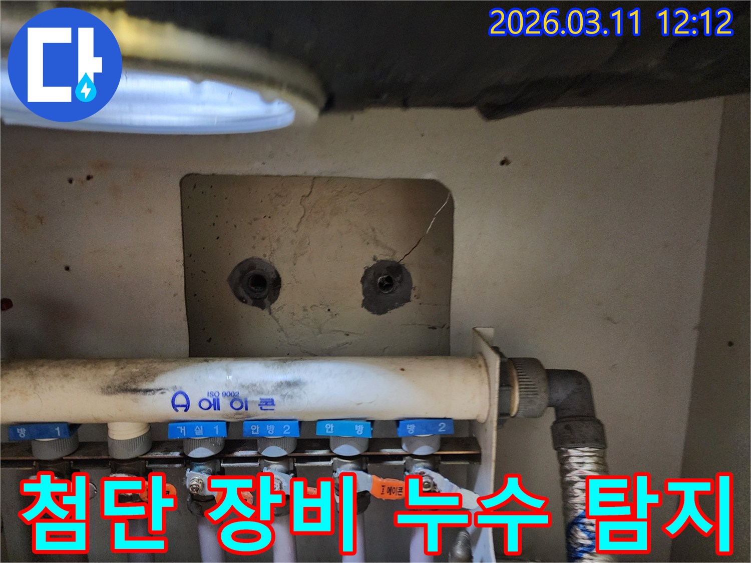 아파트 보일러 분배기-주변에서-첨단 누수 탐지 장비를-활용하여-난방 배관의-누수 지점을-정밀하게 찾아내는-누수 전문가의-모습