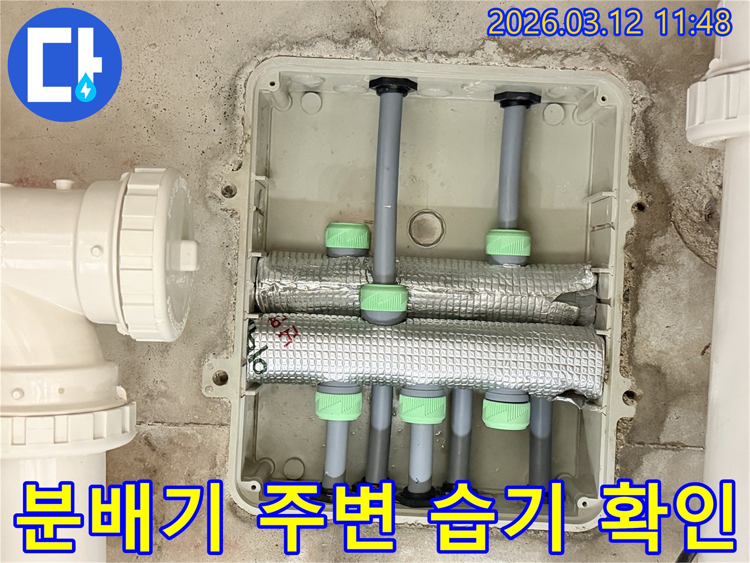 김포 아파트의-배관 분배기 주변에서-누수로 인한-습기 발생 여부를-전문가가 확인하는 모습