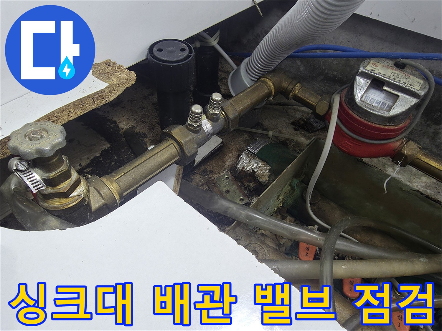 주방 싱크대 하단에 위치한 수도 밸브와 연결된 급수 배관의 상세 모습