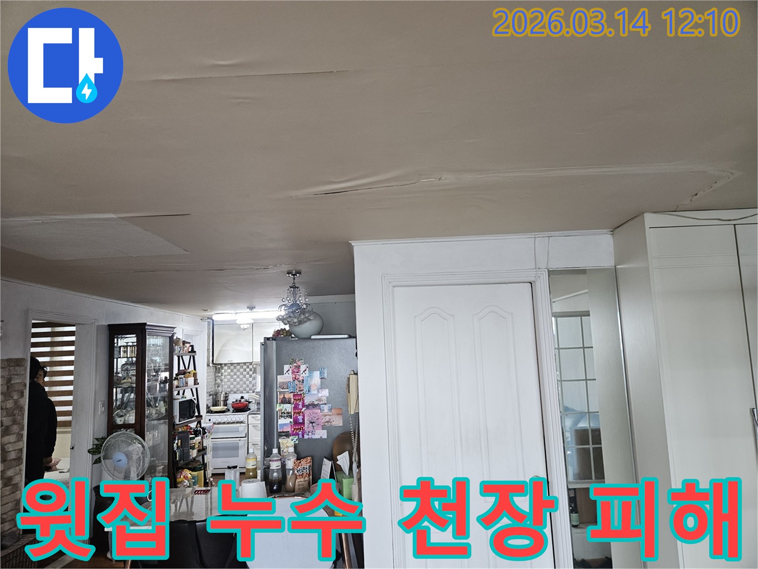 이 이미지는 윗집 누수로 인해-아파트 천장이-심하게 손상된 모습을-보여줍니다-천장 마감재가 물에 젖어-변색되고-일부가 처진 현상은-신속한 누수 원인 진단과-복구 작업이-필요함을-나타냅니다