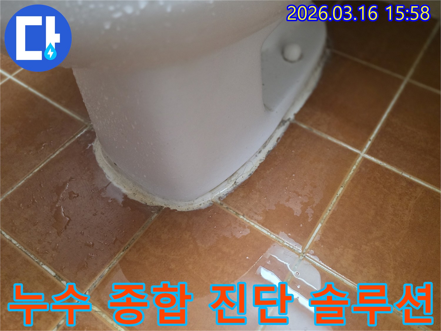 변기 하부에서 물이 새어-타일 바닥에 고여-주변으로 퍼지고 있는 모습입니다