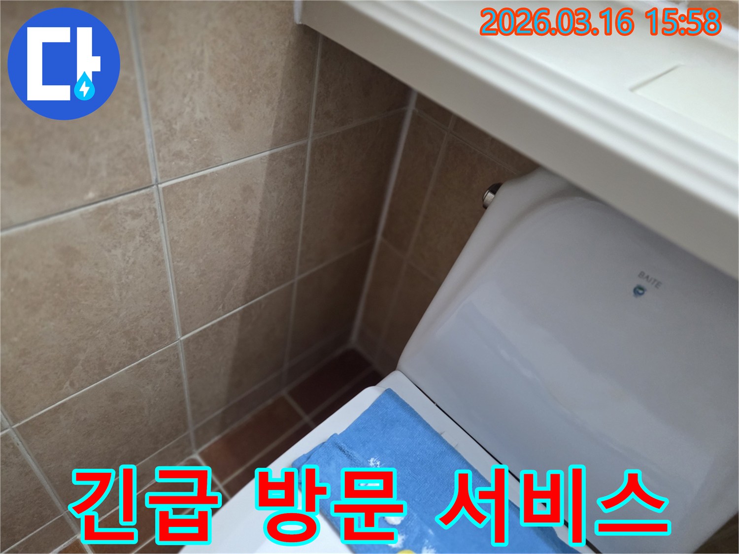오산 운암로의-한 화장실에서-변기 뒤편-벽면 타일의 젖음으로-누수 발생 시-긴급 방문 서비스를-제공하는 현장을-보여주는 사진입니다.