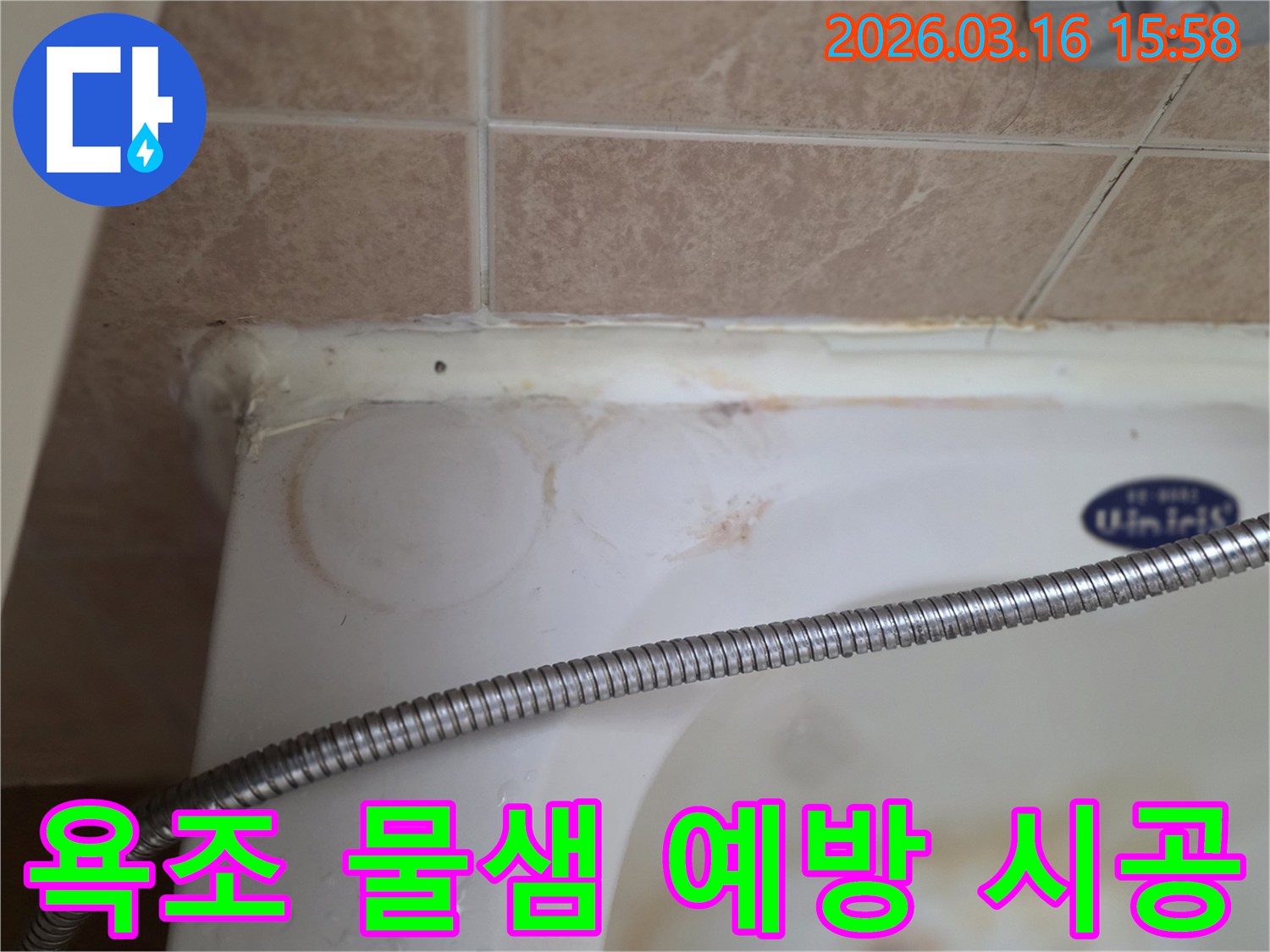 욕조와 타일 이음새의 낡은 실리콘-그리고 물이 스며들어 생긴 붉은 얼룩이 보이는-화장실 누수 현장