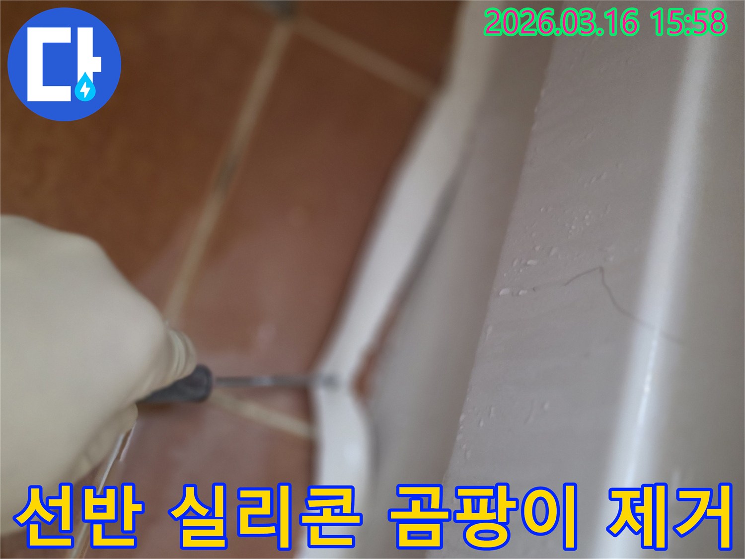 주거 공간 욕실 선반 하단의-오래되고 곰팡이 핀 실리콘을-전문가가 제거하는 작업 현장