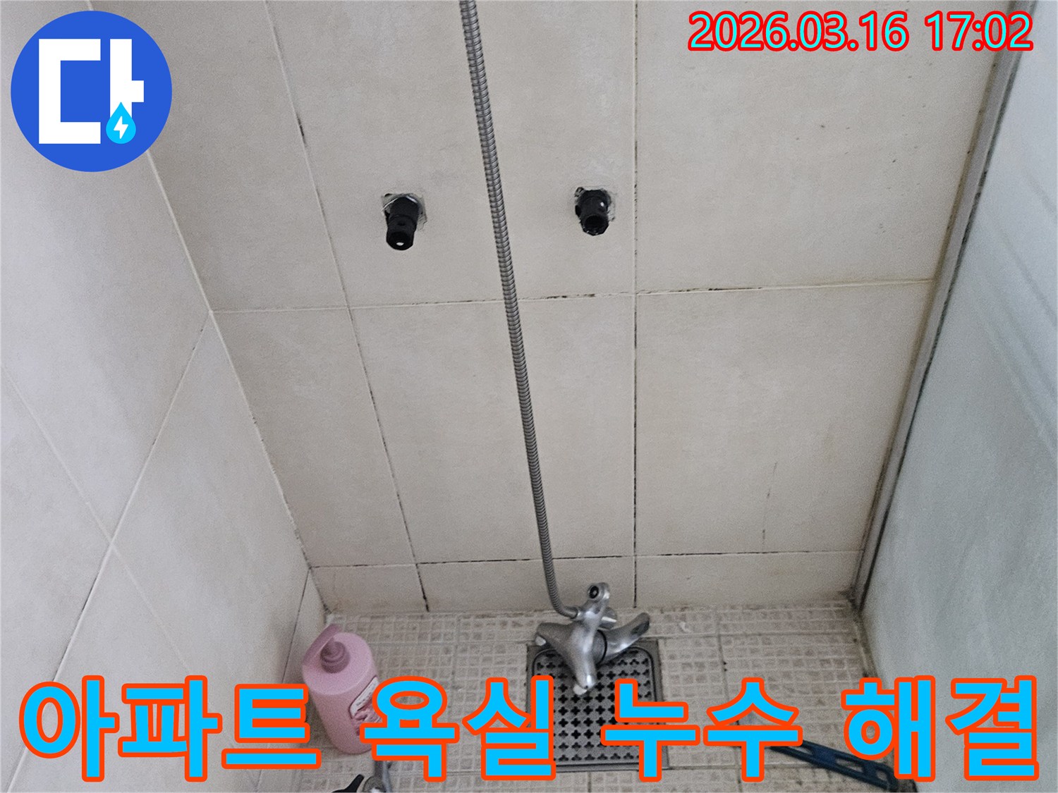 이 이미지는-화성시 병점구의 한 아파트 욕실에서-층간 누수 문제를 해결하기 위해-전문가가 점검하는 모습을 보여줍니다.