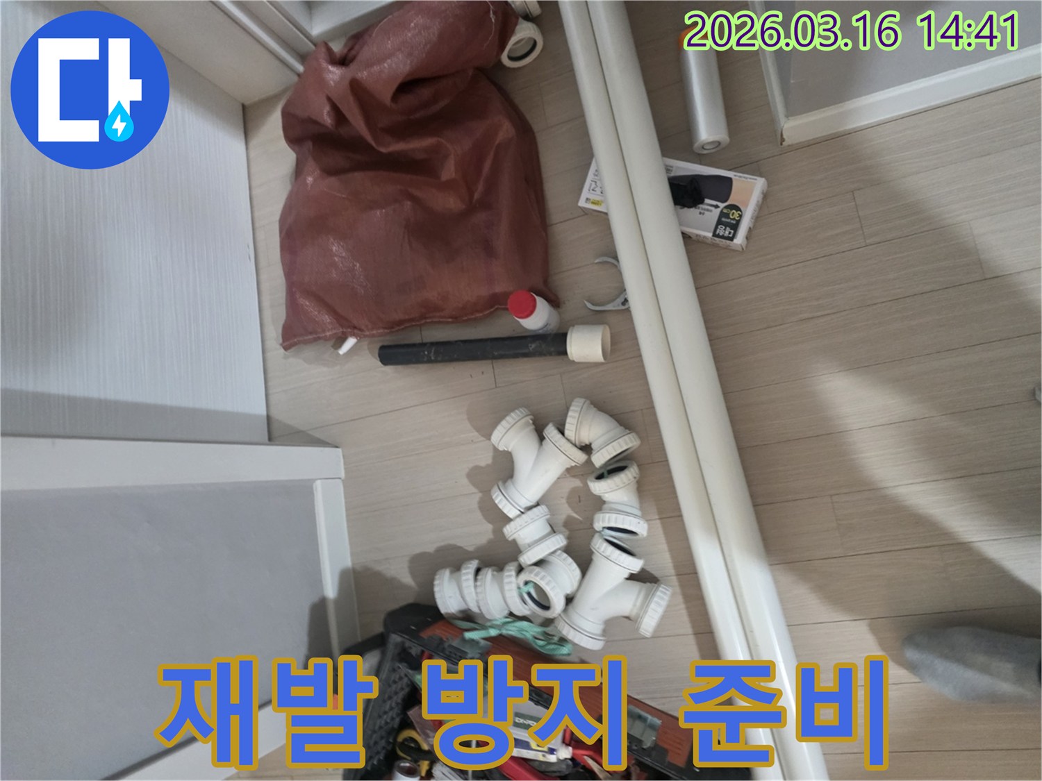 누수-수리를-위해-준비된-다양한-규격의-파이프와-연결-부속들-그리고-작업-공구들이-바닥에-놓여-있습니다