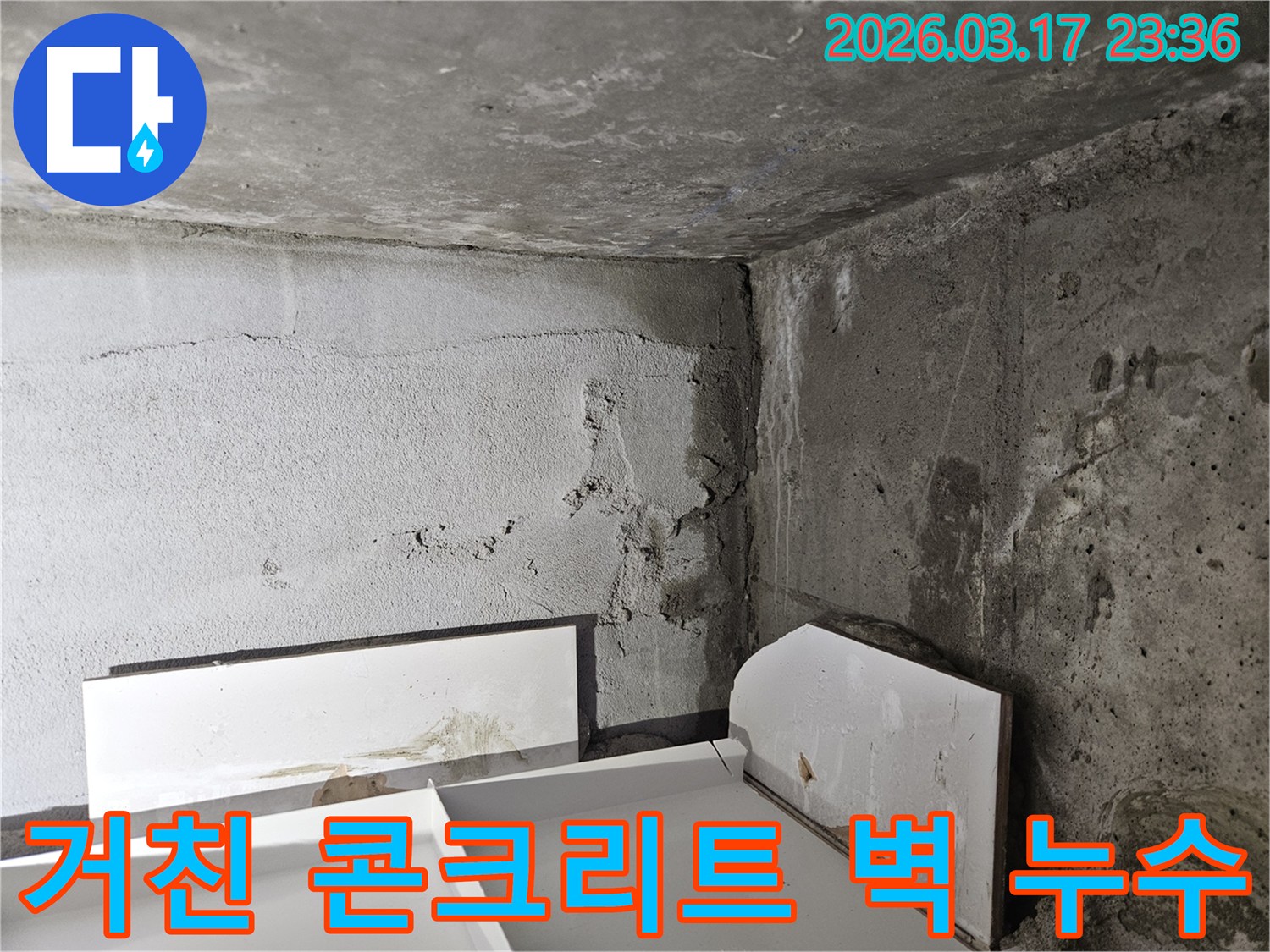 거친 표면의 콘크리트 벽면에 나타난 누수 흔적-표면 손상과 함께 물이 스며들고 있습니다.