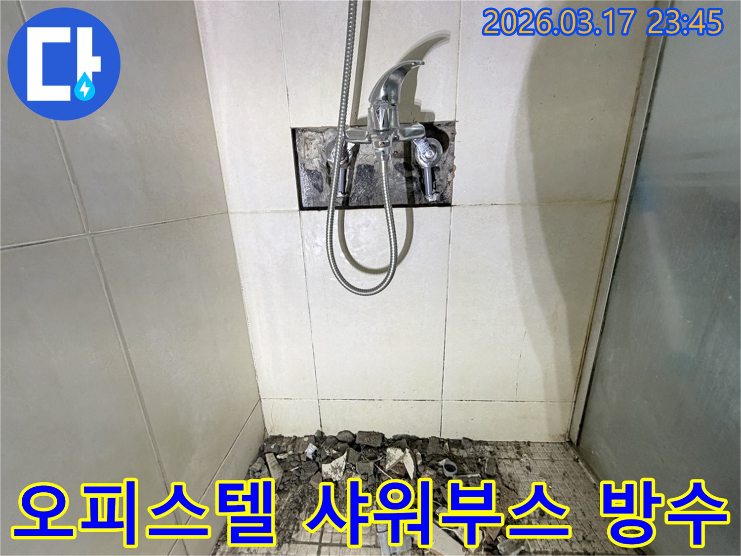 경기 화성시 병점동 오피스텔 욕실에서-샤워 부스 바닥 방수층 손상 재시공 및 타일 교체를 위해-샤워 수전이 제거되고-바닥 타일이 파손된 채로-공사가 진행 중인 모습입니다.