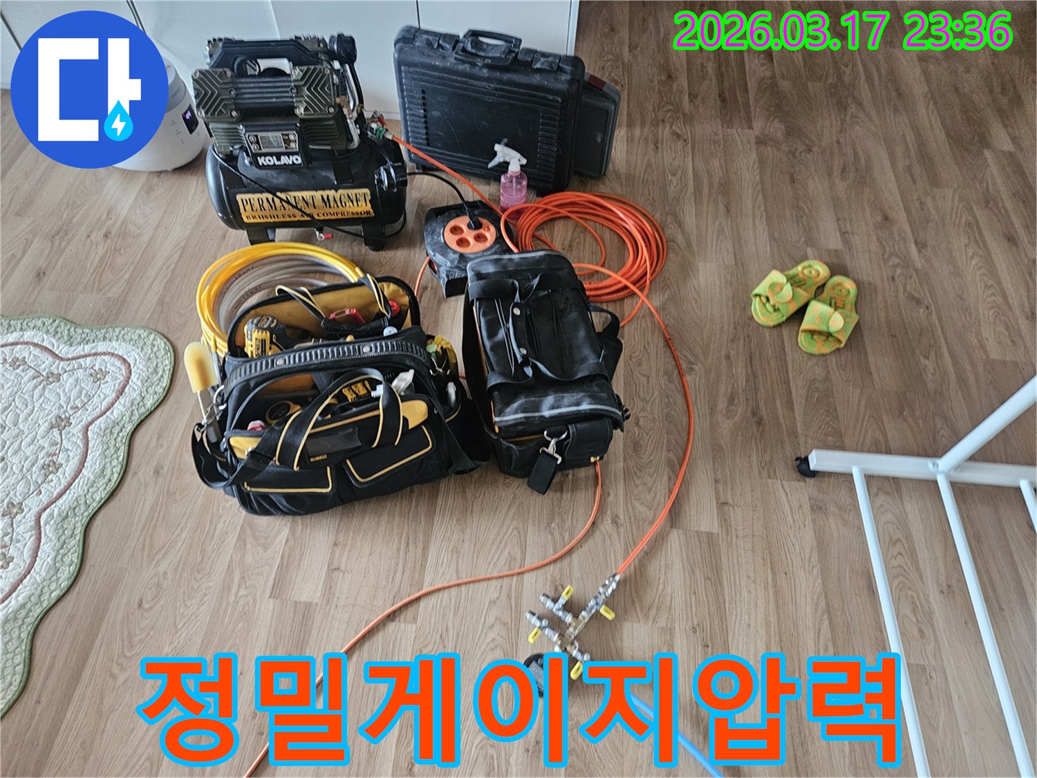 누수 엔지니어가 현장에 방문하여-배관의 미세한 압력 변화를 감지하기 위한-정밀 게이지와 호스를 연결하고 있습니다.