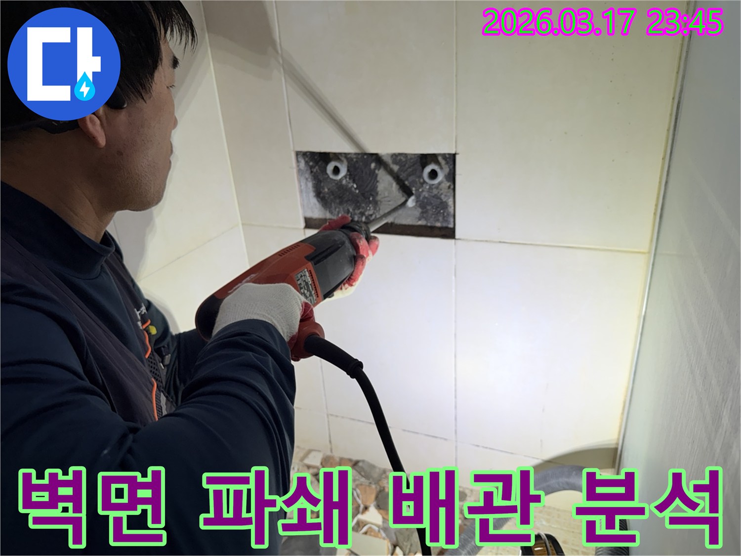 누수 전문가가 벽면 타일을 깨끗하게 파쇄하며-누수 원인인 배관의 문제점을 정밀하게 분석하는 작업을 진행 중입니다.