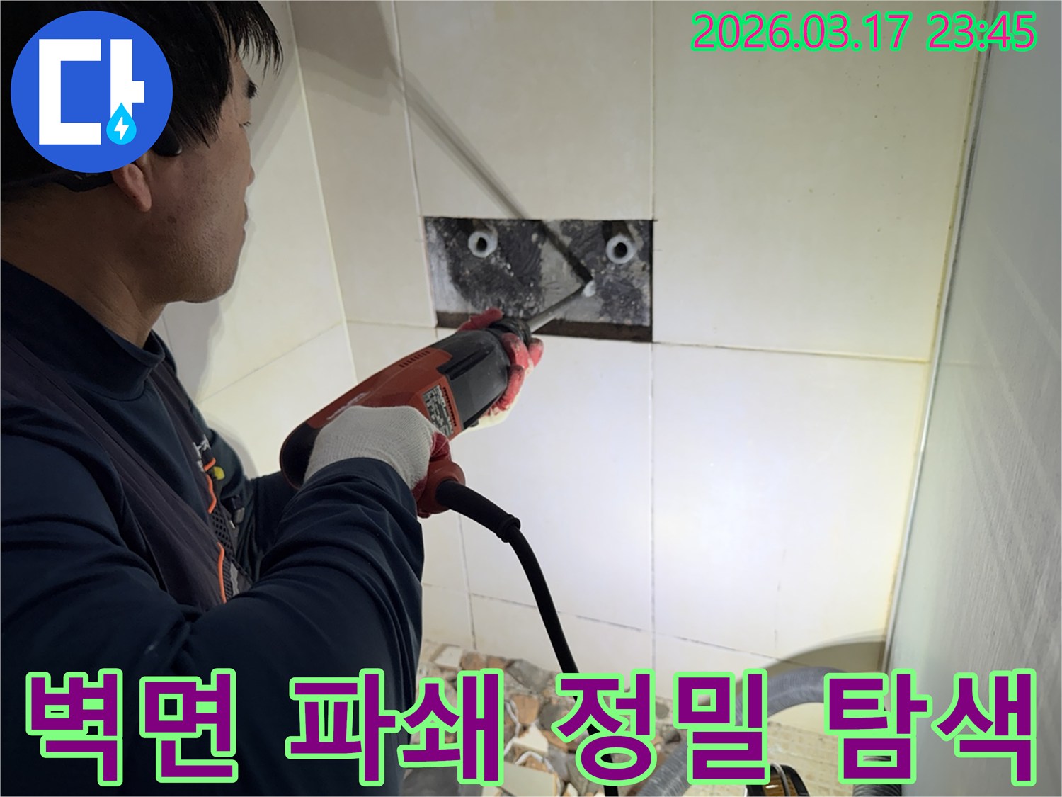 누수 전문가가 벽면 타일을 깨끗하게 파쇄하며-누수 원인인 배관의 문제점을 정밀하게 탐색하는 작업을 진행 중입니다.