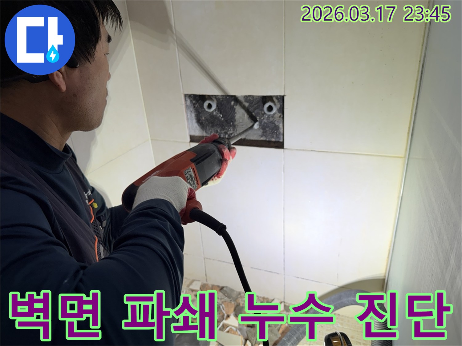 누수 전문가가 벽면 타일을 깨끗하게 파쇄하며-누수 원인인 배관의 문제점을 찾아내는 작업을 진행 중입니다.