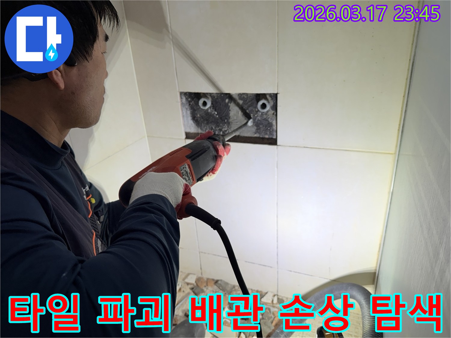 누수 전문가가 욕실 벽면 타일을 파괴하여-숨겨진 배관의 손상 부위를 정밀하게 탐색하는 작업 현장입니다.