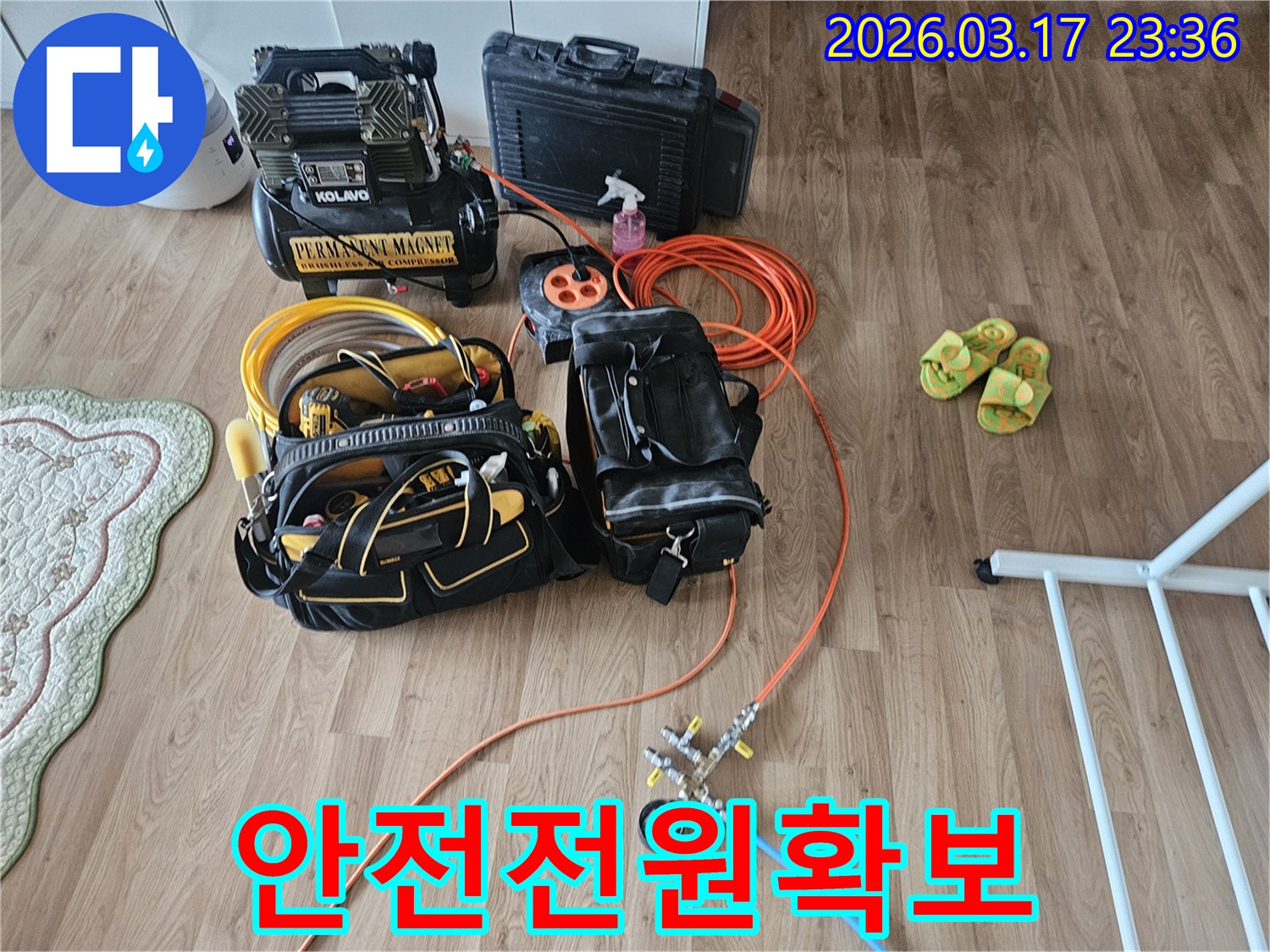 누수 탐지 장비들을 위한-안전한 전원 공급을 위해-주황색 연장선 릴이 바닥에 놓여 있습니다.
