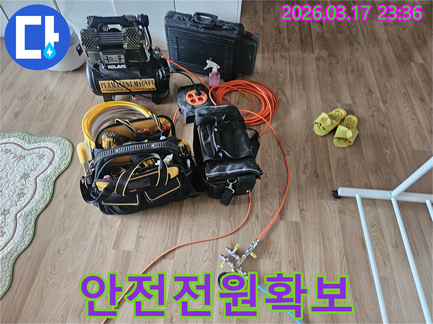 누수 탐지 장비들을 위한-안전한 전원 공급을 위해-주황색 연장선 릴이 바닥에 놓여 있습니다.