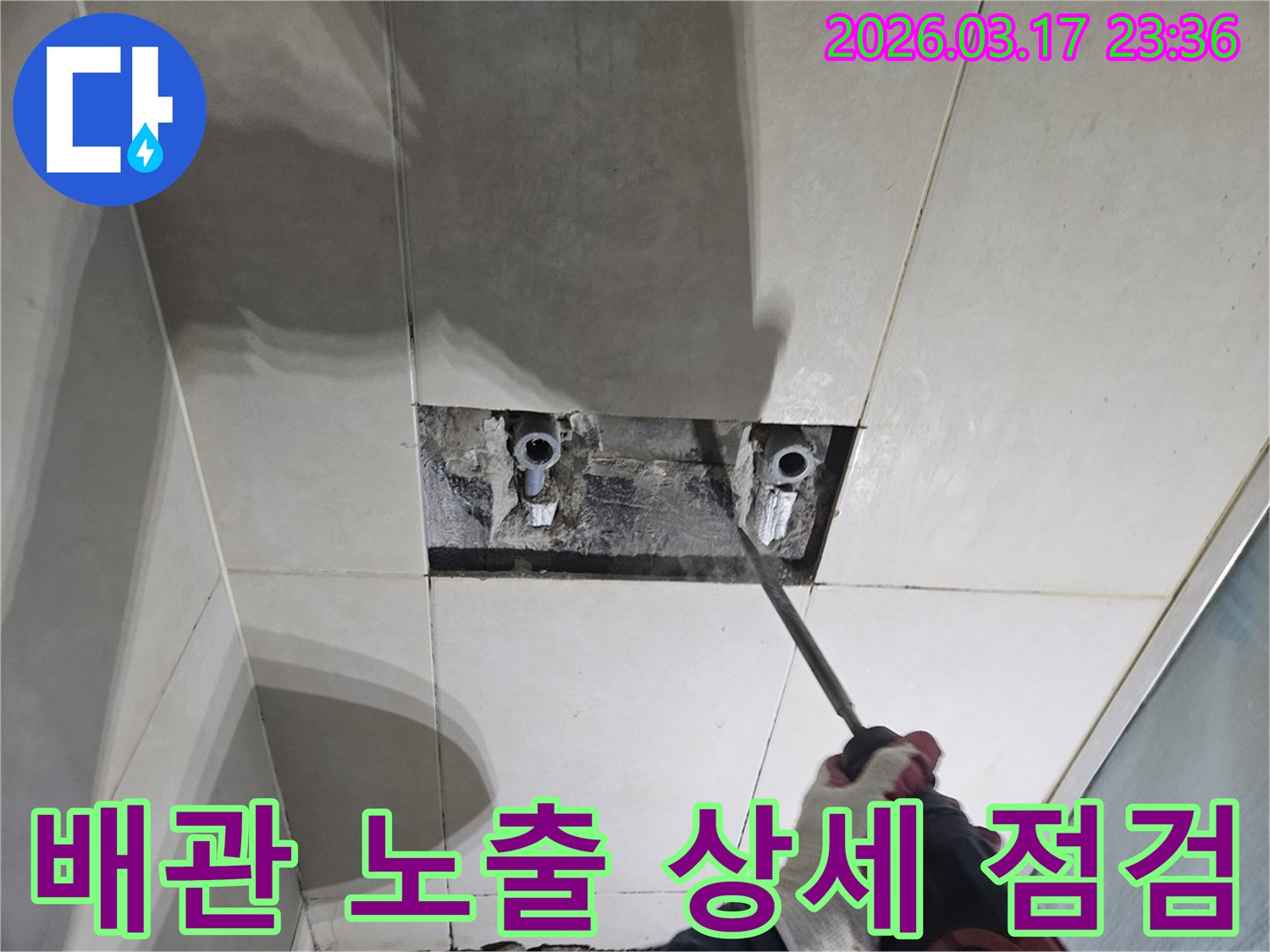 누수 해결을 위한-필수 단계로-벽면 타일 파쇄 후-배관을 노출하여-점검하는 모습입니다
