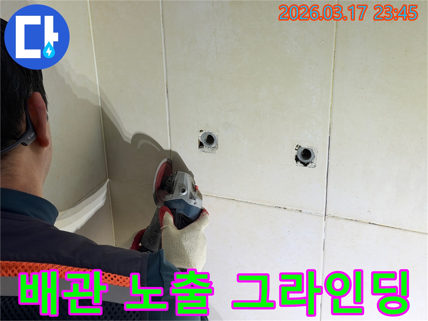 누수된 배관을-노출시키고-정밀 점검하기 위해-전문가가-타일 벽면을-그라인더로-그라인딩하는-작업을-진행하고-있습니다