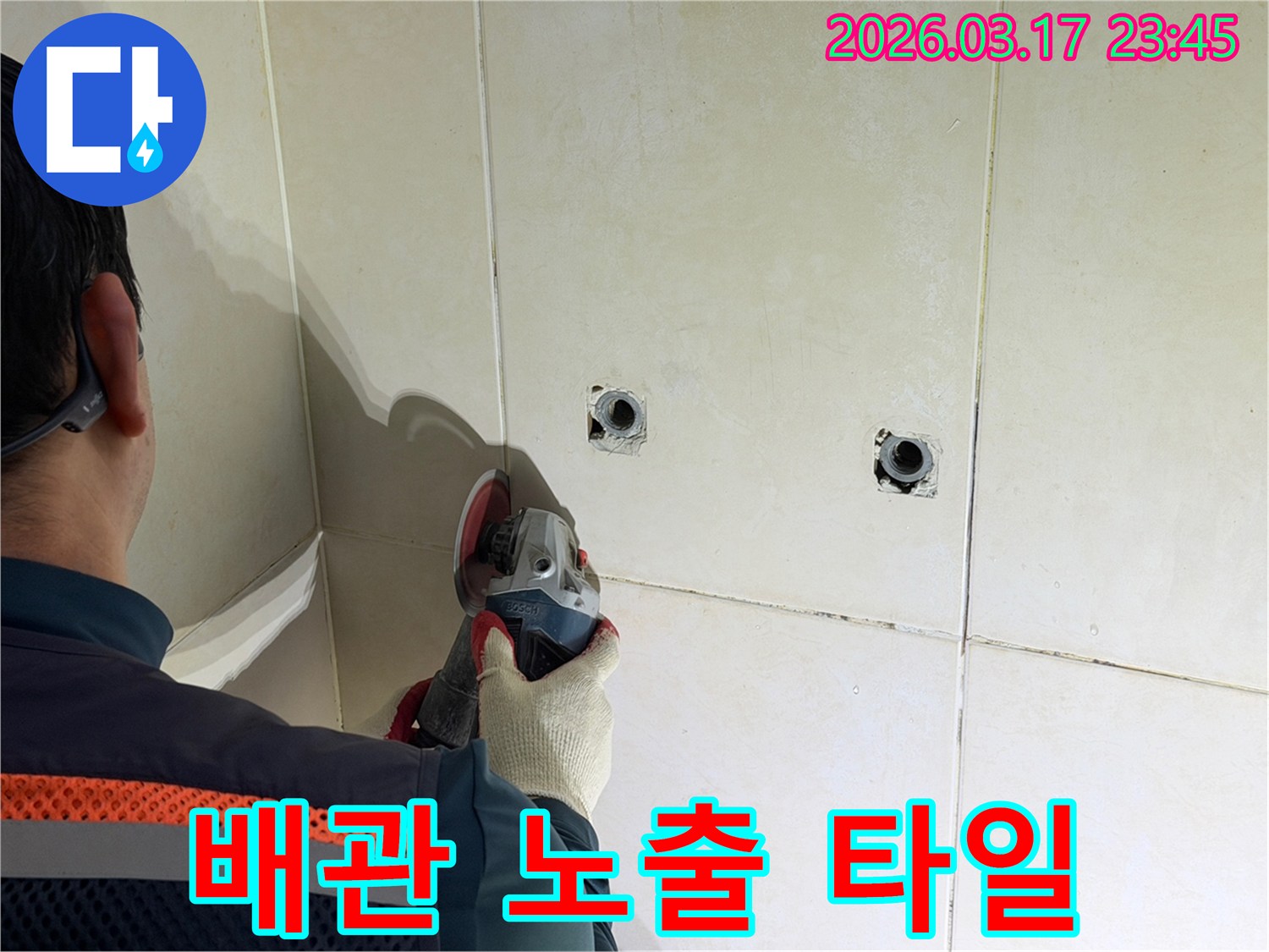 누수된 배관을-노출시키기 위해-전문가가-타일 벽면을-그라인더로-조심스럽게-커팅하고-있습니다