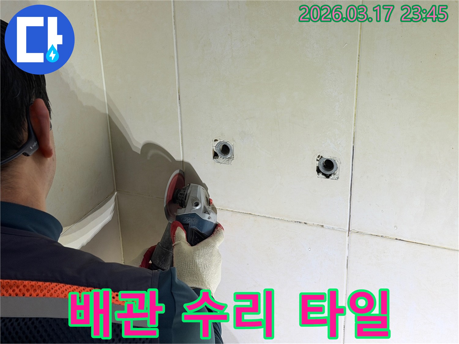 누수된 배관을-수리하기 위해-전문가가-타일 벽면을-그라인더로-안전하게-제거하는-작업을-진행하고-있습니다