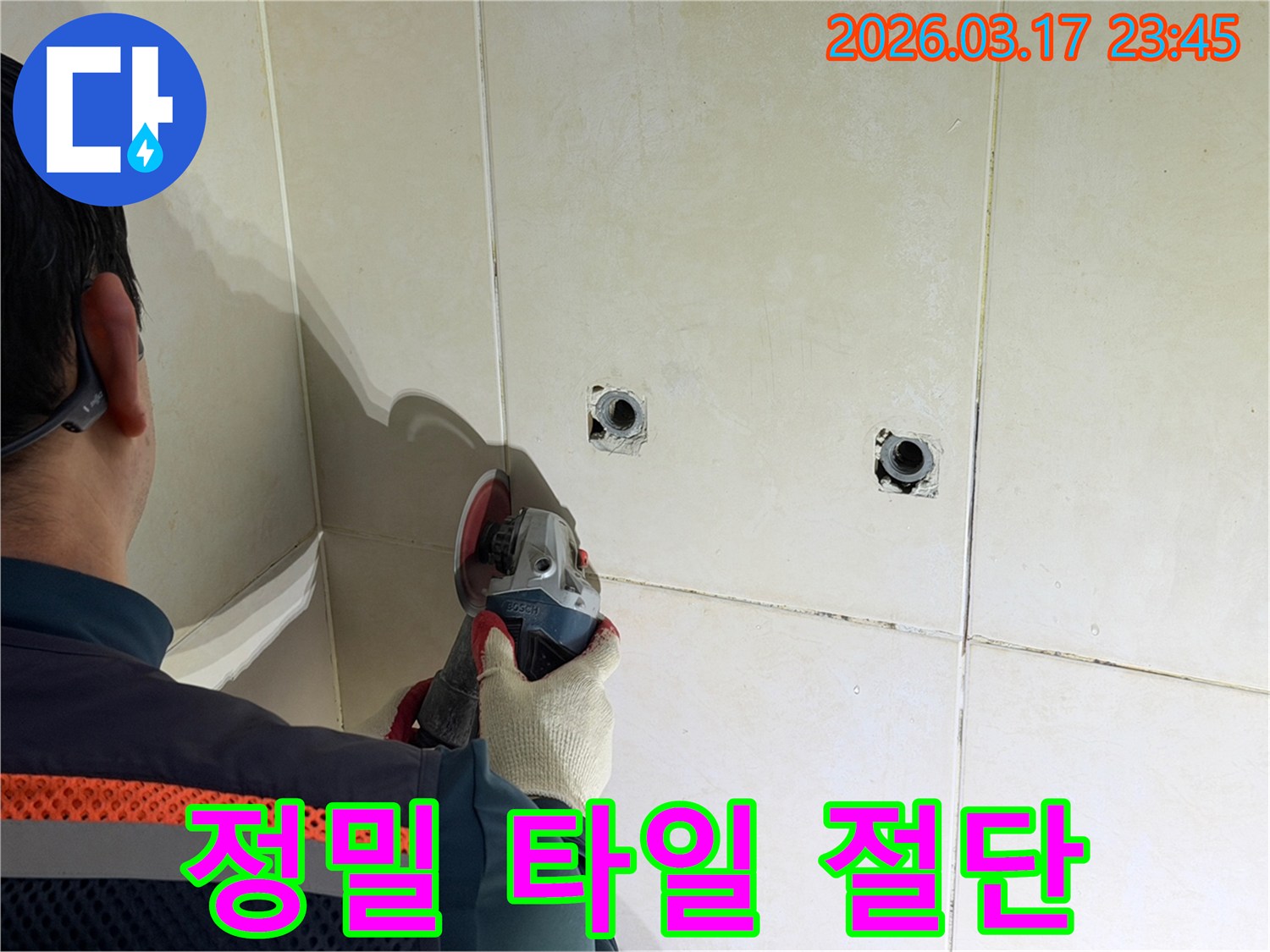누수된 배관의-손상 부위를-정확히 확인하기 위해-전문가가-타일 벽면을-정밀하게-절단하는-작업을-진행하고-있습니다