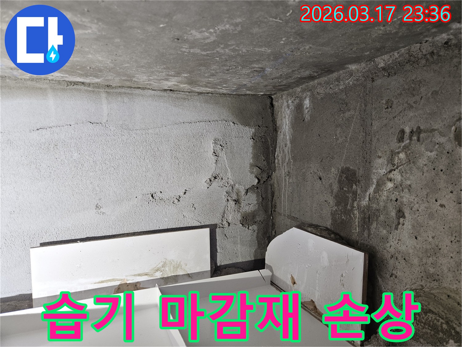 누수로 인해 바닥에 놓인 마감재가 물에 젖어 손상된 모습-내부 누수가 진행되고 있음을 보여줍니다.