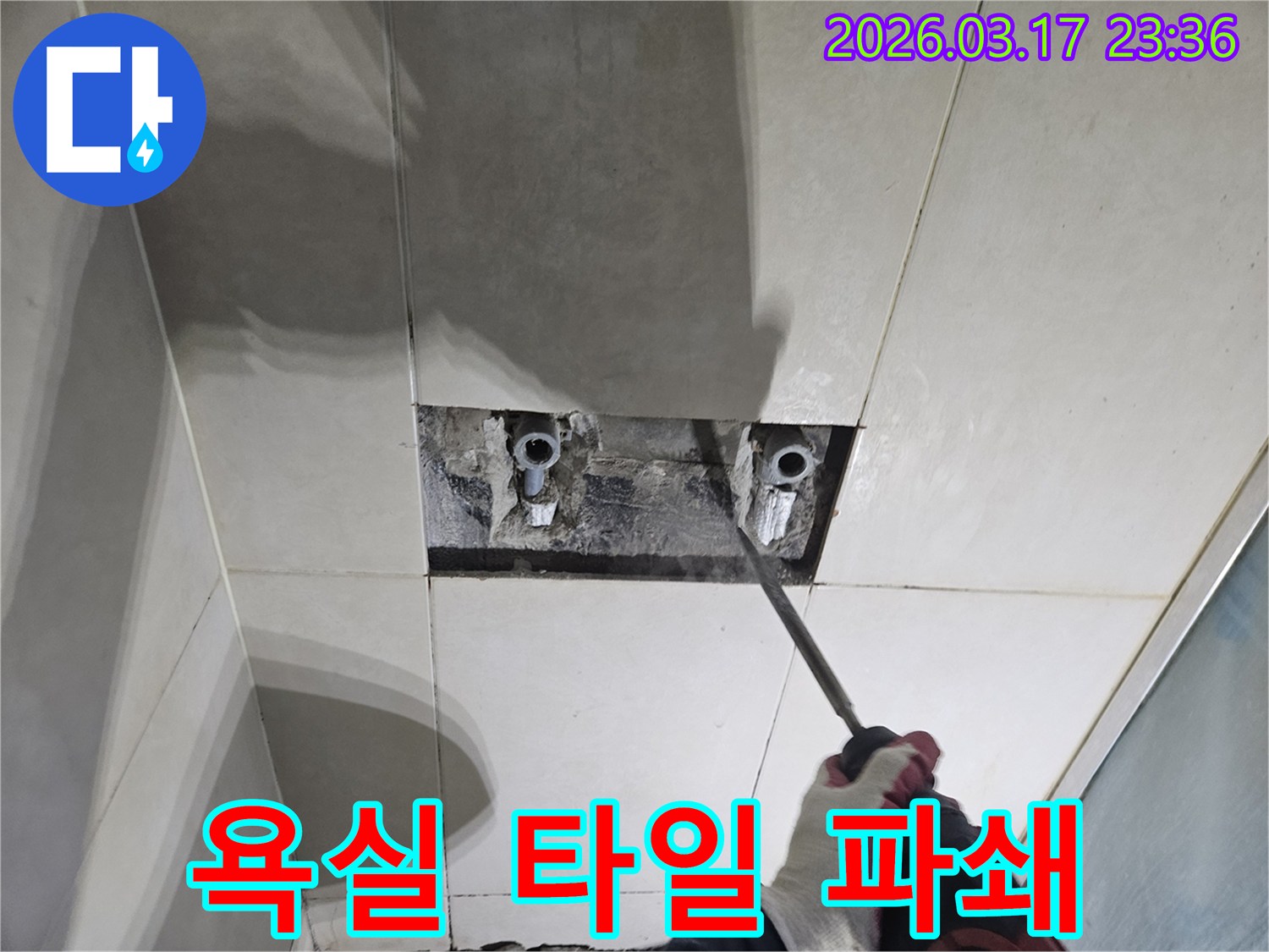 누수탐지-전문가가-욕실 벽면 타일을-조심스럽게 파쇄하는 모습