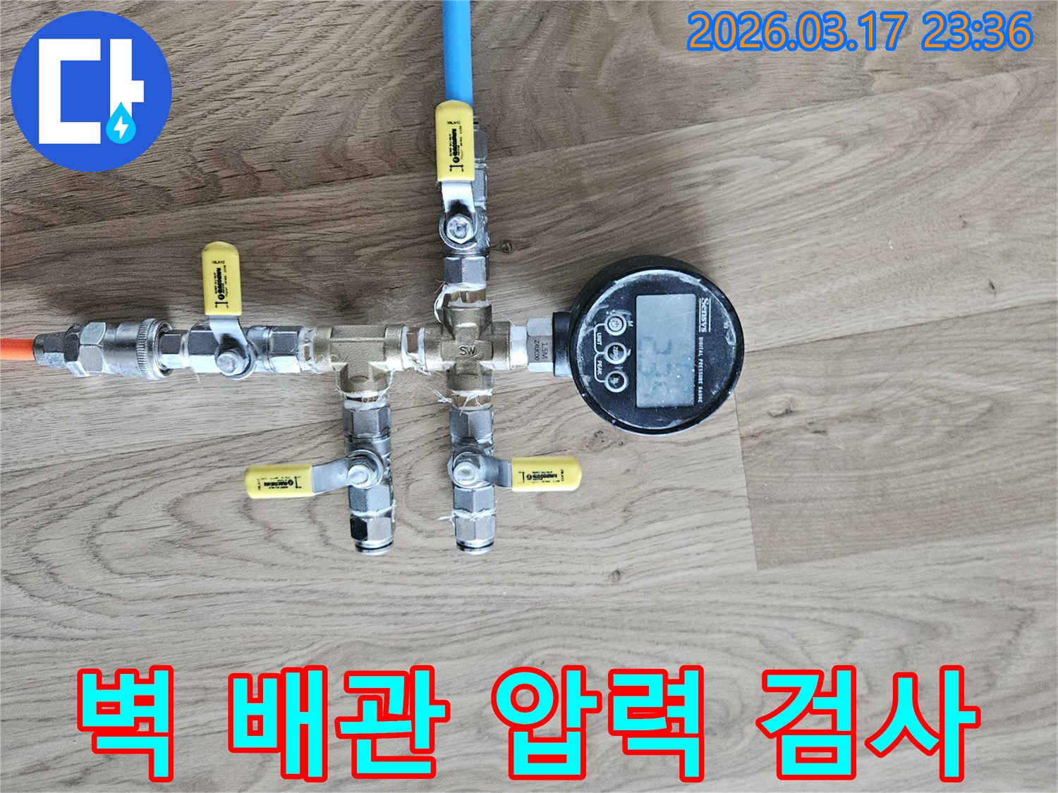 벽 내부의 누수 여부를 확인하기 위해-정밀한 압력 테스트 장비를 연결하여-수치를 측정하고 있습니다.