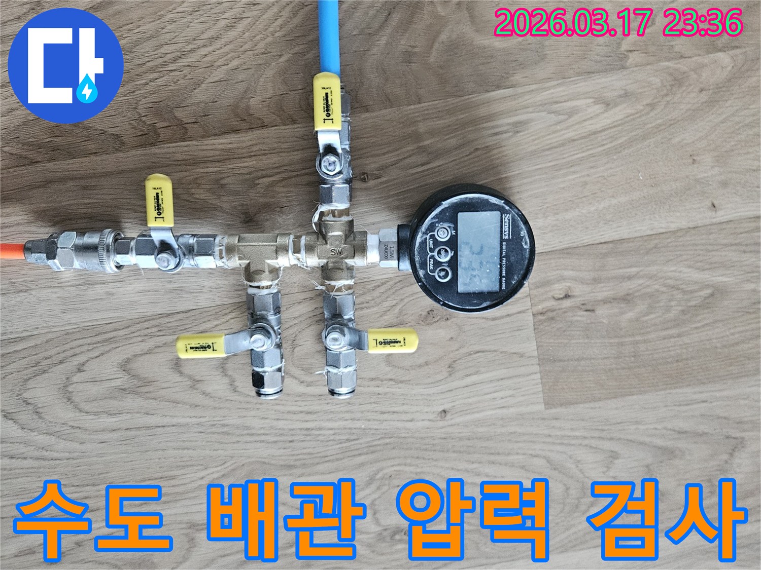 수도 배관의 누수 여부를 확인하기 위해-정밀한 압력 테스트 장비를 연결하여-수치를 측정하고 있습니다.