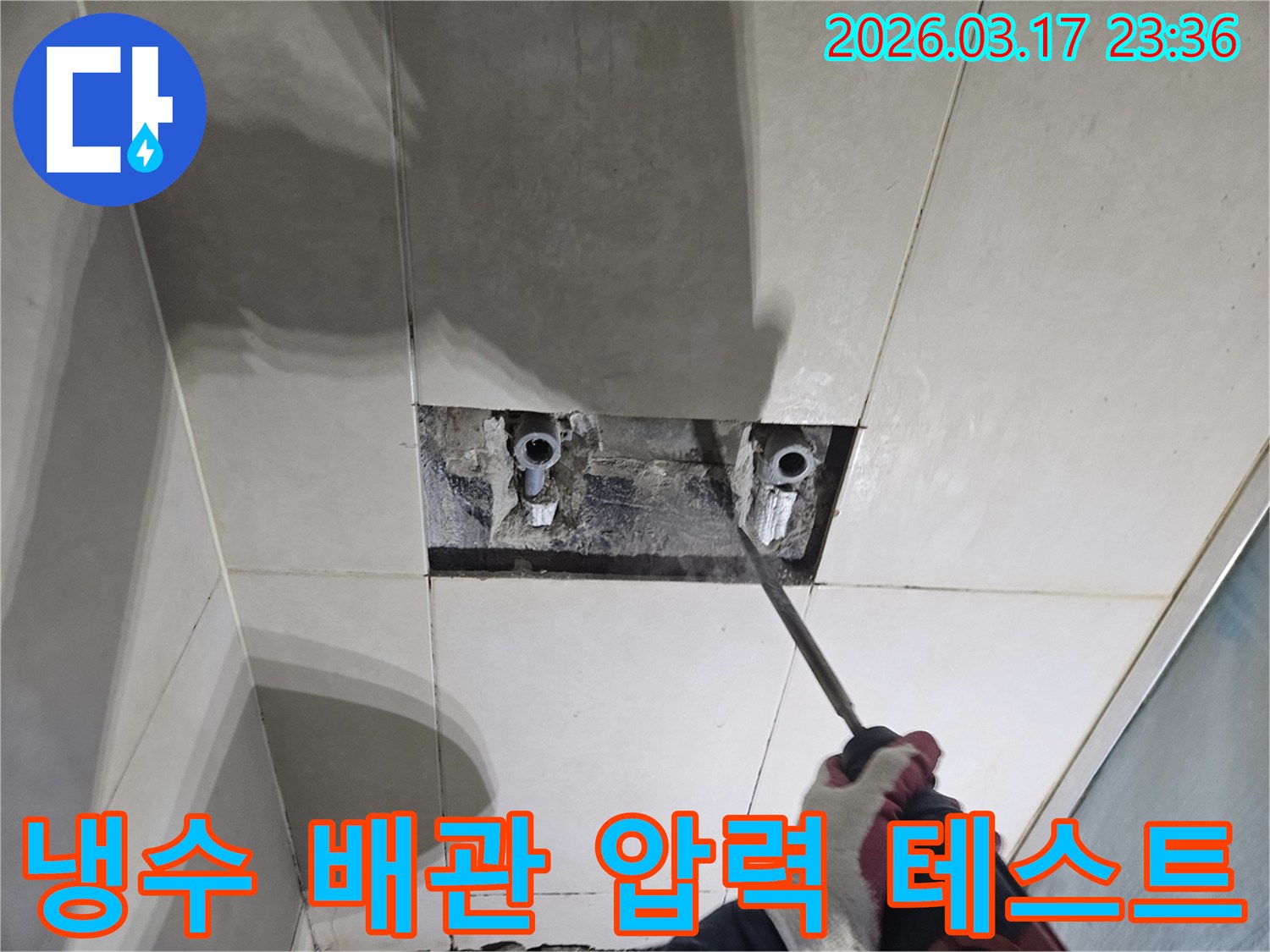 숙련된 기술자가-누수 탐지 후-타일 아래 숨은-냉수 배관을-드러내고-압력 테스트를-준비하는 작업
